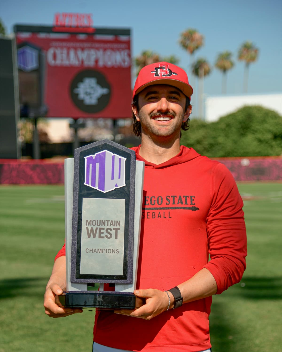 Blake McDonald holding the Mountain West championship trophy at San Diego State